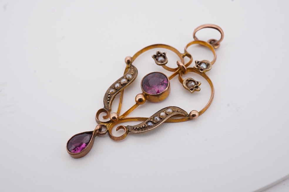 An Edwardian 15ct, diamond and seed pearl cluster set stick pin, 54mm, a similar yellow metal and cabochon garnet set stick pin and an Edwardian 9ct and gem set drop pendant. Condition - poor to fair